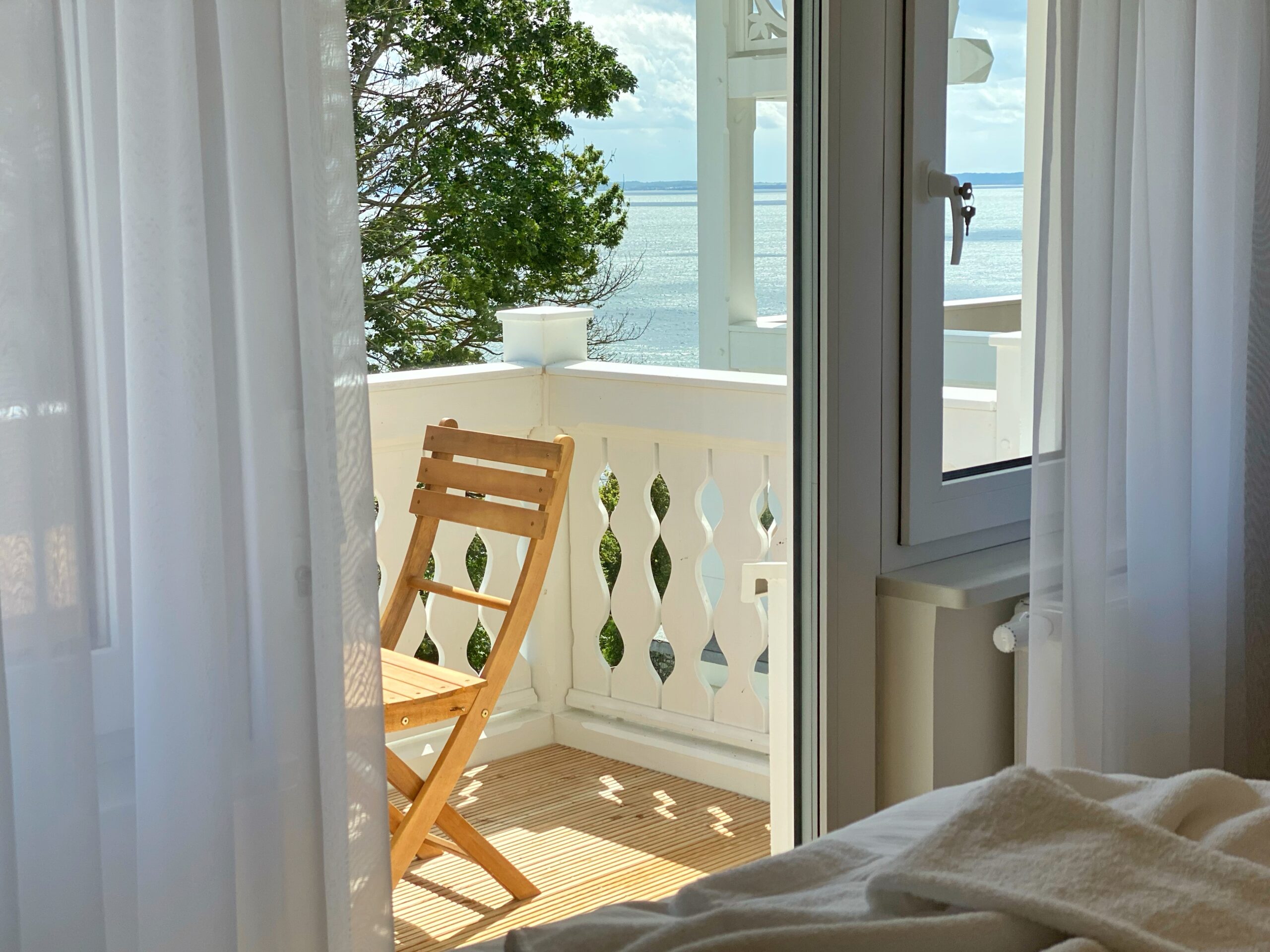 Balkon einer Ferienwohnung auf Rügen mit Kinderhochstuhl und Meerblick